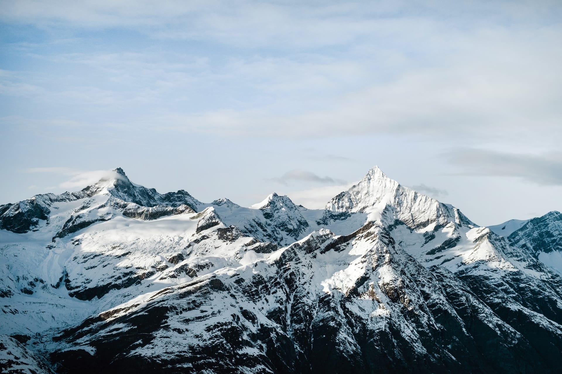 Cresta de montañas rocosas con cimas cubiertas de nieve