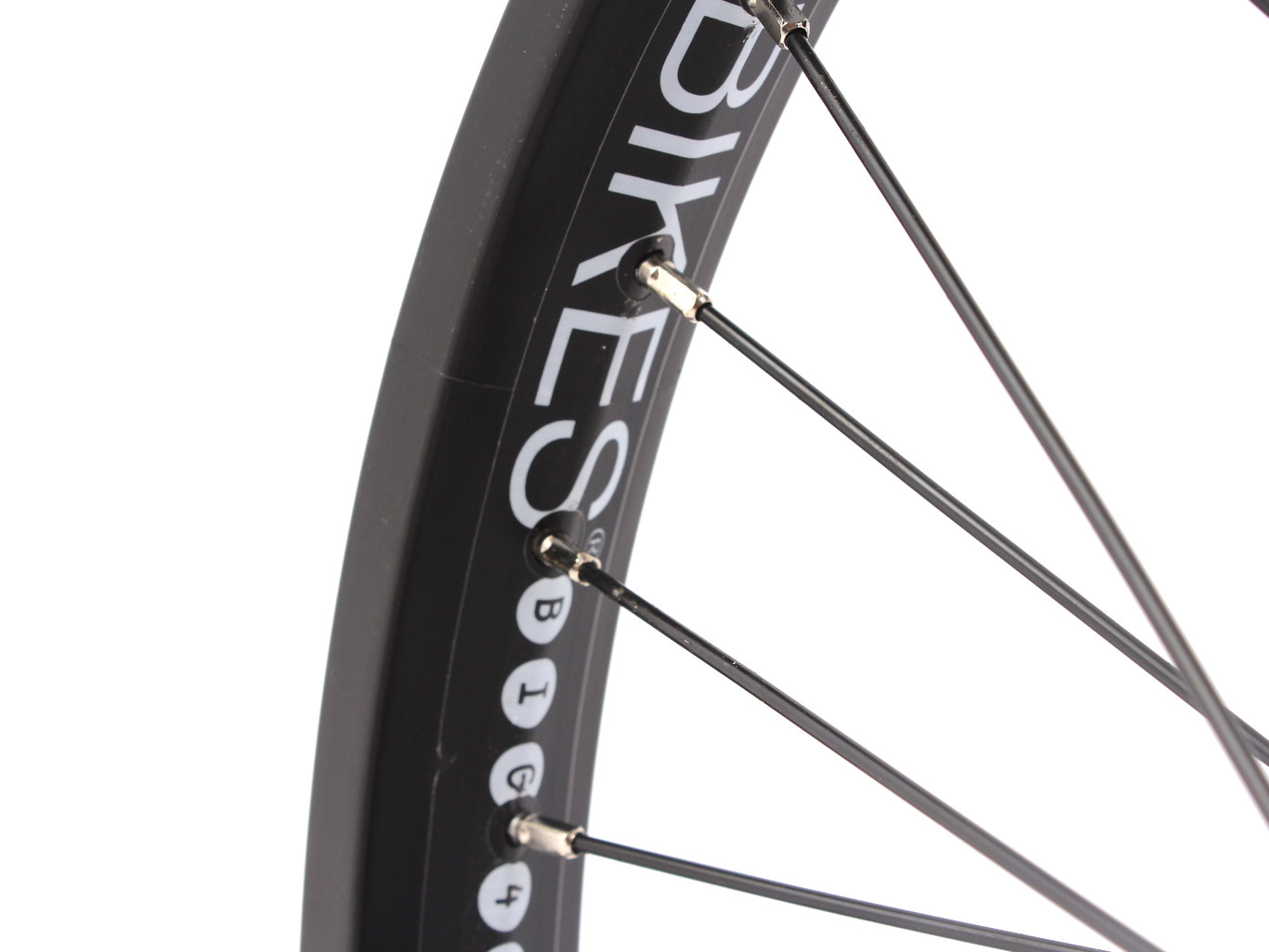 Nahaufnahme weißer KHEBikes Aufschrift auf schwarzer Felge mit schwarzen Speichen Nahaufnahme weißer KHEBikes Aufschrift auf schwarzer Felge mit schwarzen Speichen