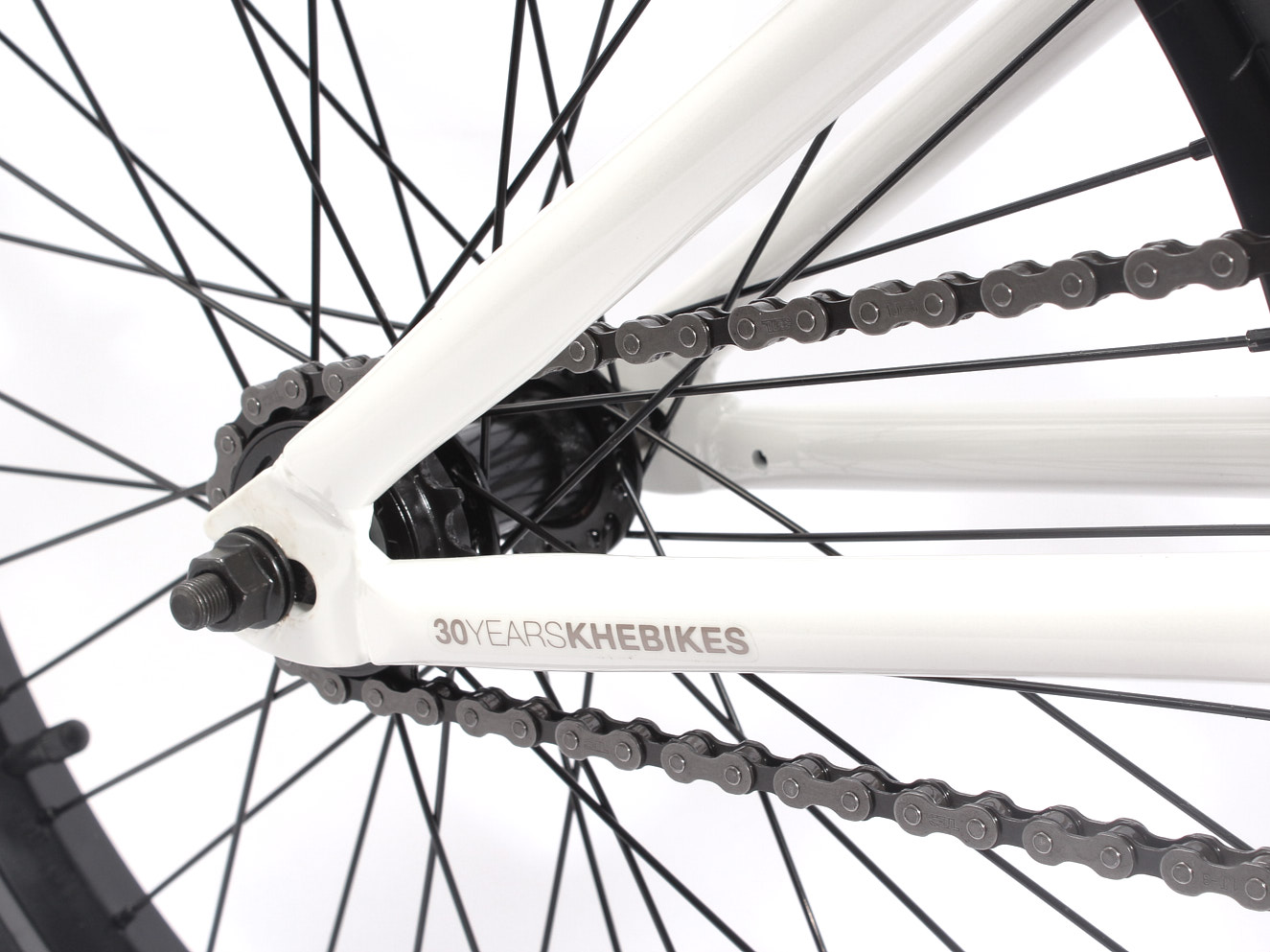 Nahansicht Hinterrad mit weißem Rahmen und KHEbikes Logo und Kette